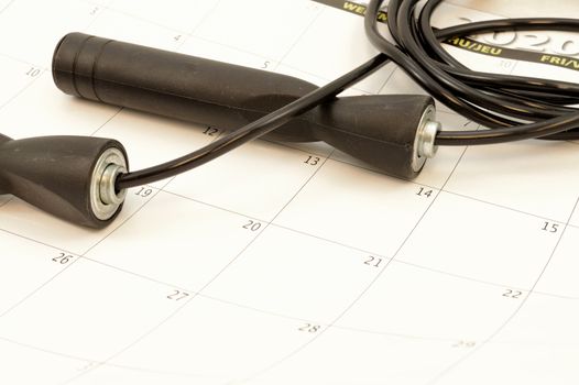 A skipping rope and calender represent a gym routine.