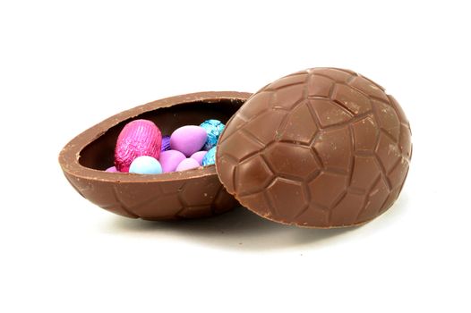 An isolated hollow Easter Egg opened to show the inside treats.