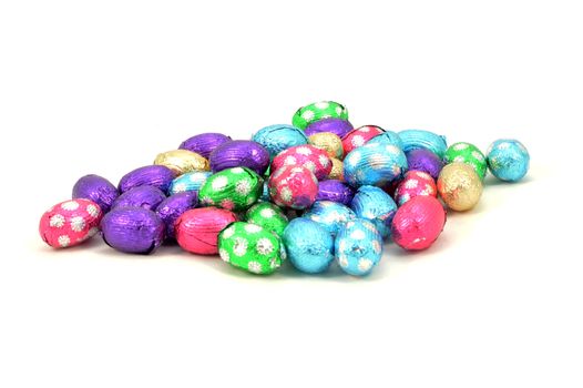An isolated over white background bunch of chocolate Easter eggs wrapped in a festive foil.