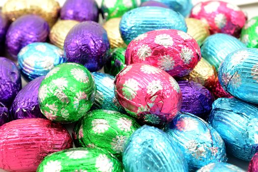 A full frame view of many chocolate Easter Eggs wrapped in a festive foil.