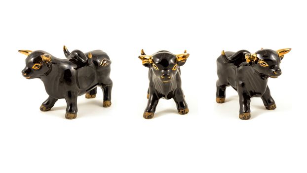 A 16x9 resolution composite of three black porcelain bulls with gold details isolated over a white background.