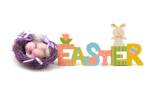 An isolated over white background image of a colorful Easter cutout sign with a purple nest and eggs for the holiday season.