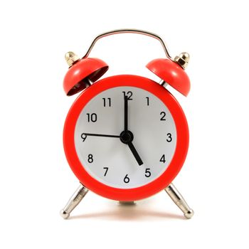 An isolated over a white background image of a traditional red alarm clock.