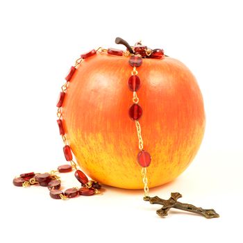 An isolated red apple and Christian rosary over a white background.