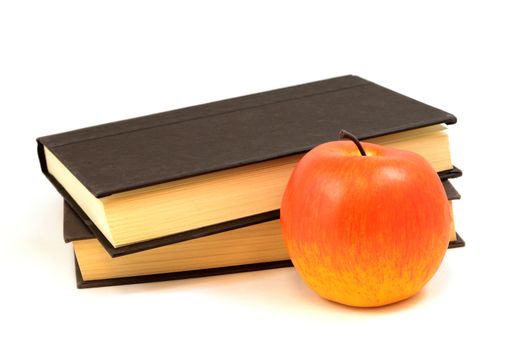 An isolated set of books and a red apple for educational reading and learning.