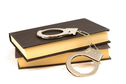 An isolated set of books and handcuffs for the educational study of law and order.