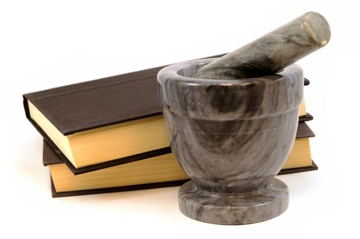 An isolated set of books and a mortar and pestle to learn about food preparatioin.