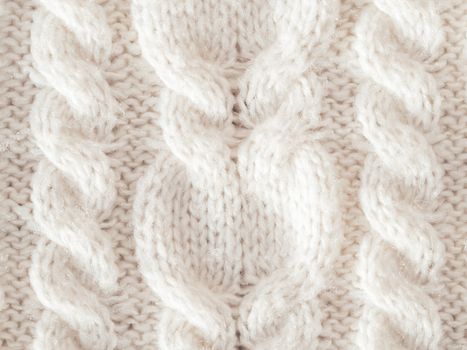 Hand made cable-knit sweater sweater. Texture of warm knitted fabric with pattern. White cardigan. Cozy autumn outfit for snuggle weather.