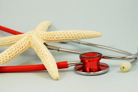 An illustrative tropical starfish and red medical stethoscope for concepts related to healthcare needed while on vacation.