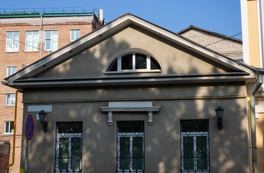 Exterior facade of a one-story gray house. Urban vintage background.