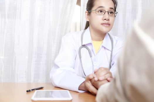 Doctor working in her clinic and listening to the patient, Doctor hold hand of patient and listening explaining his symptoms. healtcare and assistance concept