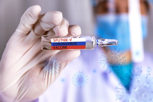 Covid-19 coronavirus vaccine Close up hands of scientist show Covid-19 vaccine name sputnik-v in glass vial with virus background Hands of doctor wear latex glove holding Covid-19 vaccine in bottle