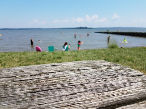 wooden table and people in the water at a beach