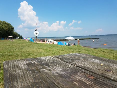 wooden table and people in the water at a beach