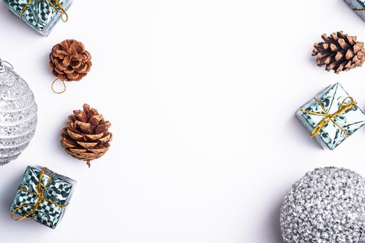 Christmas New Year composition. Gifts, fir tree cones, silver ball decorations on white background. Winter holidays concept. Flat lay, top view, copy space