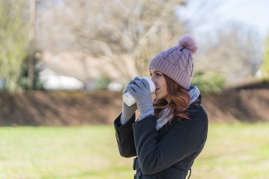 A gorgeous blonde model enjoys a winters day outdoors while drinking her favorite drink