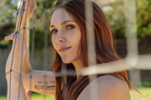 A redhead fitness model preparing to play volleyball