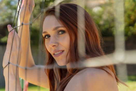 A redhead fitness model preparing to play volleyball