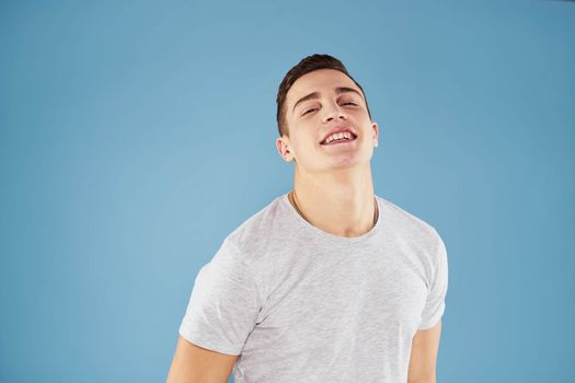 Emotional man in white t-shirt cropped view on blue background lifestyle. High quality photo