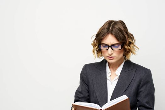 Business woman with notepad and glasses work light background cropped view of suit model. High quality photo