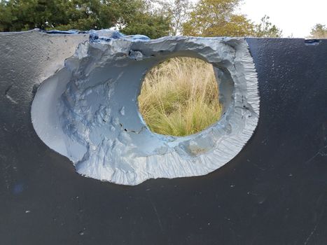 large hole or damage in broken metal wall outdoor