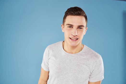 Emotional man in white t-shirt cropped view on blue background lifestyle. High quality photo