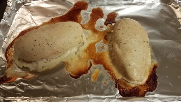 seasoned chicken breast on metal foil baking tray