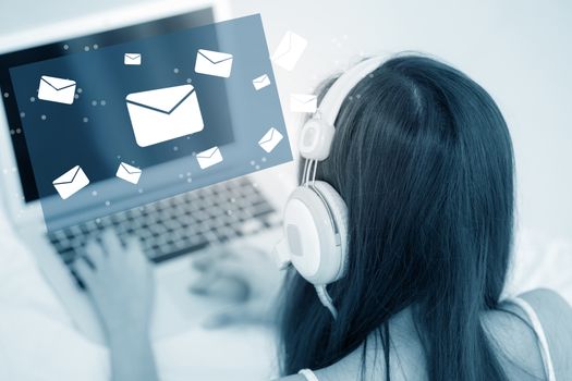Beautiful asian young woman using a laptop computer keyboard with head phone of sending email for contact on network internet in blue tone, girl using notebook, communication concept.