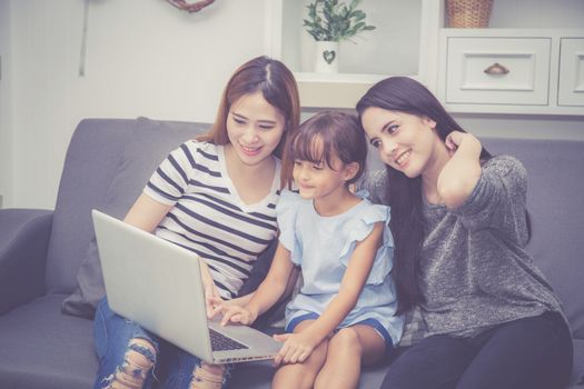 Mother, Aunt and kid having time together lerning with using laptop computer at home with relax and happy on couch, education and lifestyle concept.