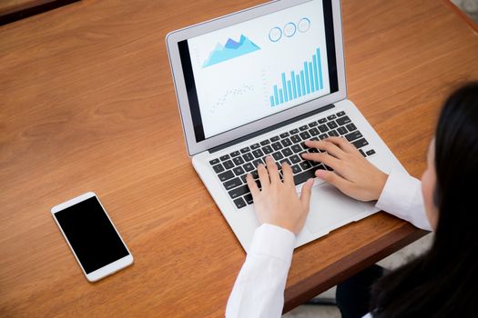 Closeup business woman work with finance analysis and planing data on laptop on wood table, typing and looking graph with computer statistic for success, business concept.