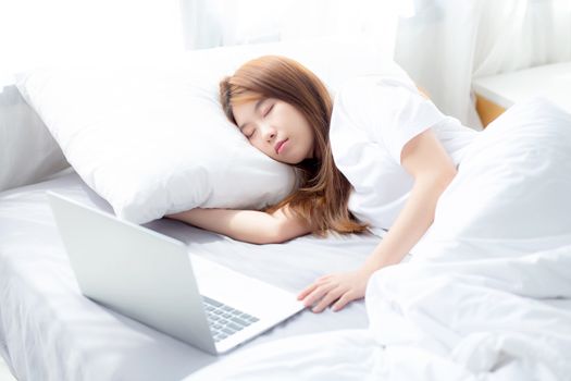 Beautiful of portrait young asian woman with laptop lying down in bedroom, girl tired sleep and relax with computer notebook, resting and healthcare concept.