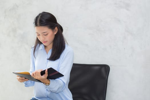 Beautiful of portrait business asian young woman reading on notebook with success on cement background, girl looking note excited, freelance and education concept.