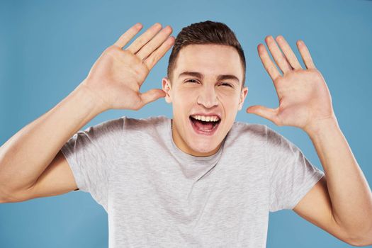 Emotional man in white t-shirt cropped view on blue background lifestyle. High quality photo