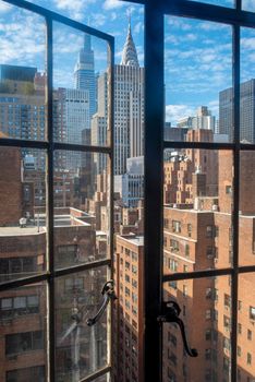 Beautiful New York summer cityscape with blue sky and an open vintage window. Full frame with copy space.