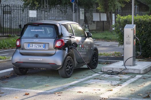 terni,italy october 28 2020:electric car being recharged attached to the column