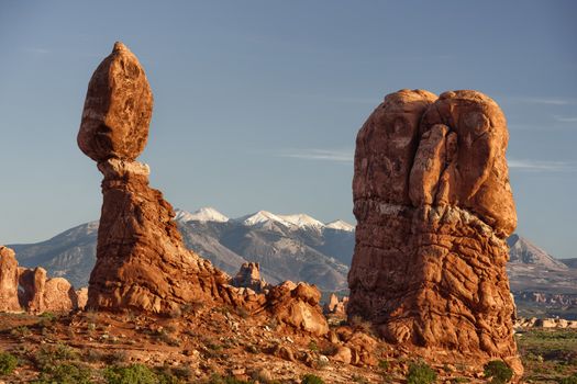 Balanced Rock with La Sal Mountains in the background in warm sunlight, Arches National Park, Utah, USA