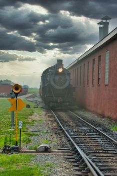 Steam Engine Locomotive with Passenger cars Arriving into Station