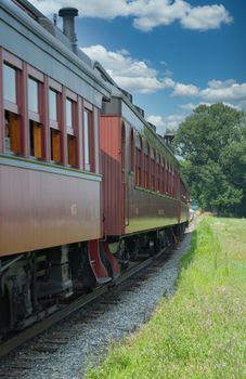 Steam Passenger Train Traveling Thru Countryside from Train View on a Sunny Day