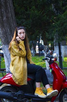 Woman on the scooter in the park, beautiful and casual