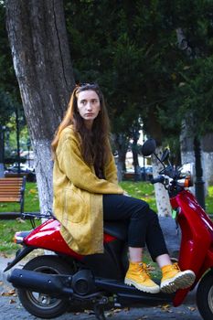 Woman on the scooter in the park, beautiful and casual