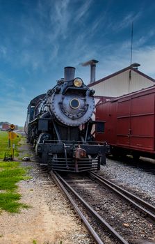 Steam Engine Locomotive with Passenger cars Arriving into Station