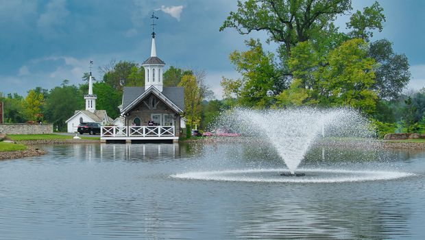Old Restored White Barns with Cupolas and 5 Pointed Stars by a Pond with a Fountain