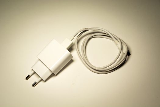 White phone charger with rolled-up cable, top view