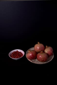 Pomegranate close-up with seeds in bowl close-up, Black background, Black background, macro photography