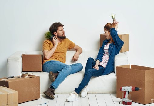 Man and woman in new room stuff in boxes moving family interior. High quality photo