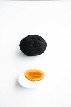 An old duck egg recipe in ash. Salty pickled duck egg in ash on a white background.