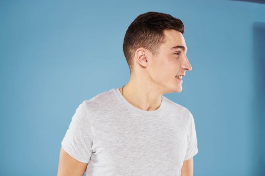 Emotional man in white t-shirt cropped view on blue background lifestyle. High quality photo