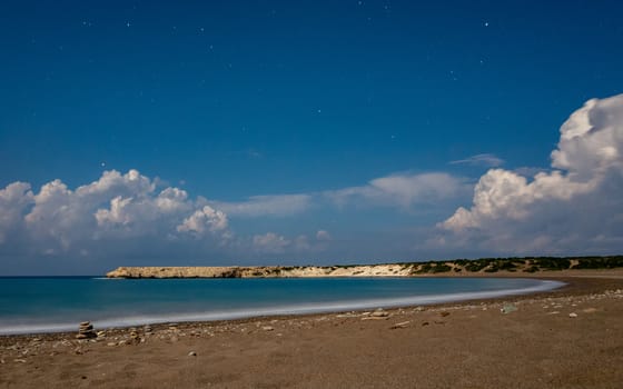 Sandy and pebble beach of the Mediterranean Sea, shot in calm weather at night with a long exposure.