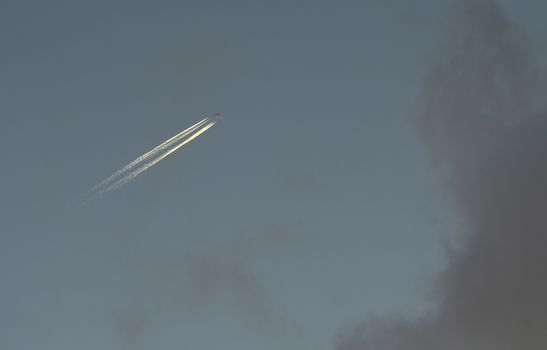 A plane with a reversible trail following it in the blue sky.
