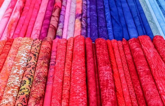 Detailed close up view on samples of cloth and fabrics in different colors found at a fabrics market.